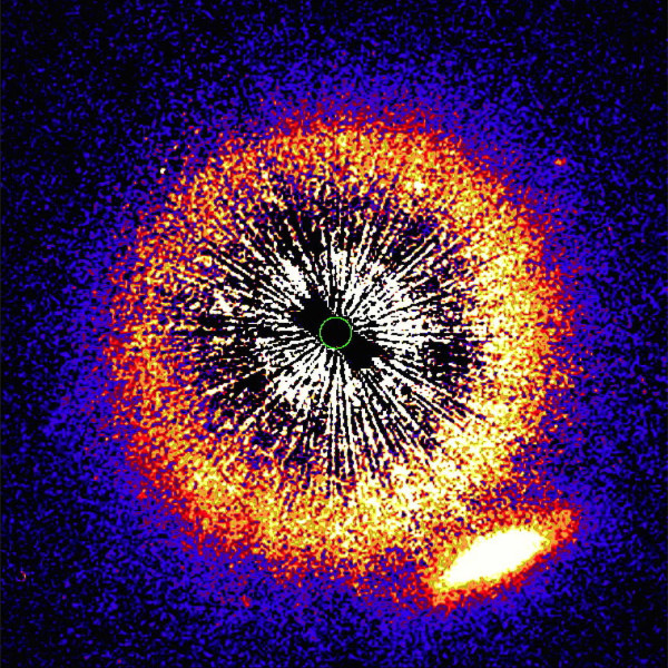 La galassia in basso a destra inizia il suo viaggio dietro una stella circondata da un disco di polvere e detriti. La sua luce subirà modifiche che permetteranno di studiare la composizione e la struttura di questo disco che si mostra frontalmente. Fonte: Hubble S.T.