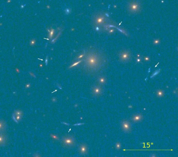 Le immagini multiple della nuova galassia ultra luminosa sono indicate dalle frecce bianche. Fonte: IAC e HST